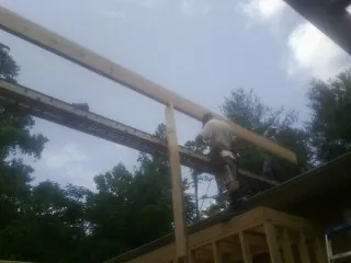 Carpenter setting a ridge beam over a new addition frame — Ice Dam Removal by Roofing Brothers in Veteran