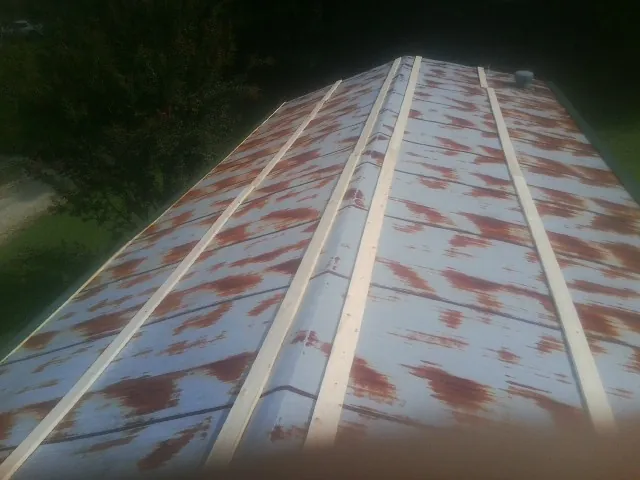 Rusted metal roof panels with new wood purlins before replacement — Storm Damage Roof Repair in Veteran by Roofing Brothers