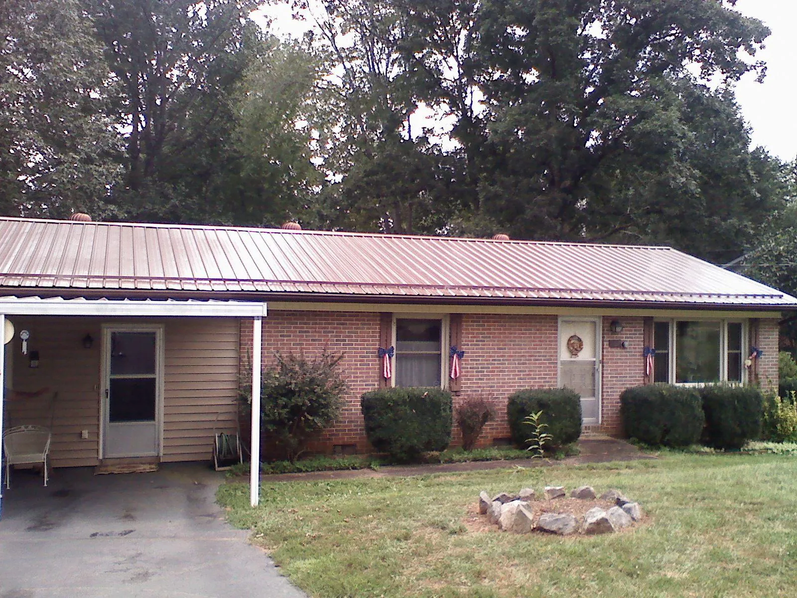 Bronze metal roof and carport on a brick ranch home — Roof Repair work by our crew in Veteran